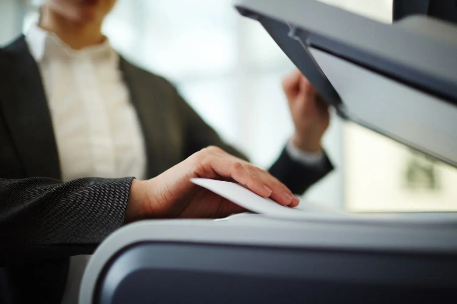 Collaboratrice numérisant un document papier sur un multifonction de bureau